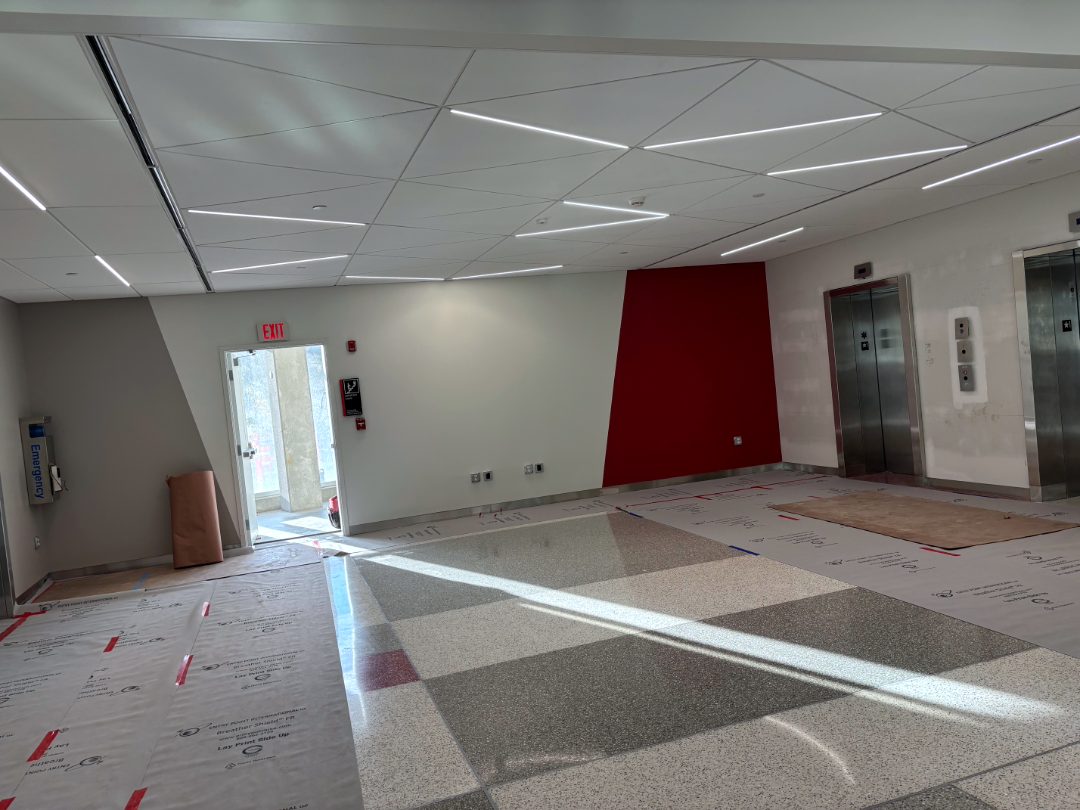 Elevator lobby with angled ceiling panels and diagonal linear lights